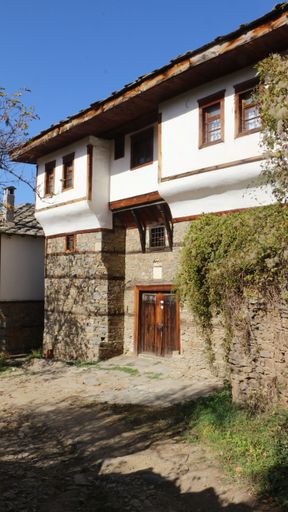 A vertical shot of an old countryside house in a small village under the blue sky on a sunny day