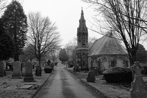 Grayscale image of a cemetery with a historical church in the background