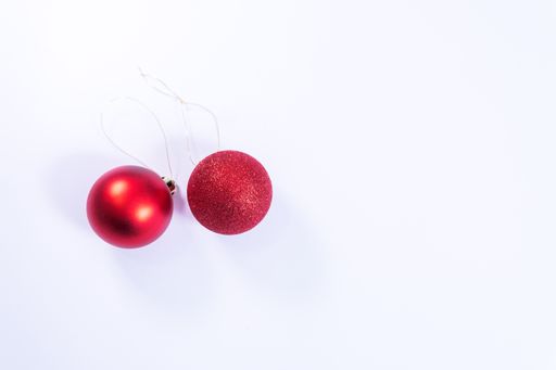 A white background with red Christmas ornaments and space for text