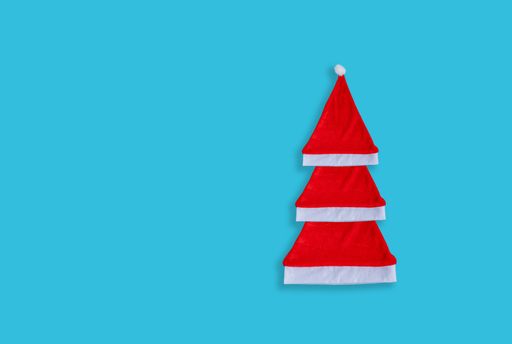 A high angle shot of Santa Clause hats on a blue surface