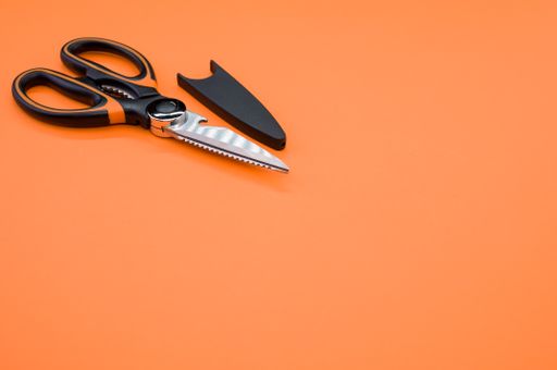 A closeup shot of scissors isolated on pink background. Cutting tool with zigzag blades, copy space