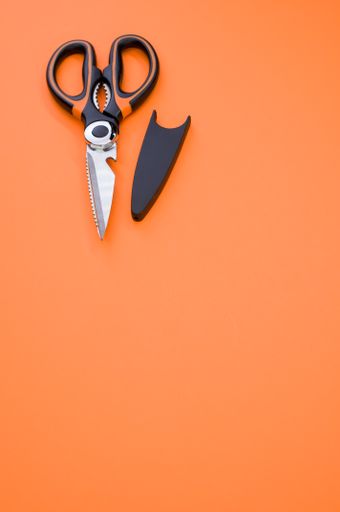 A vertical shot of scissors isolated on pink background. Cutting tool with zigzag blades, copy space