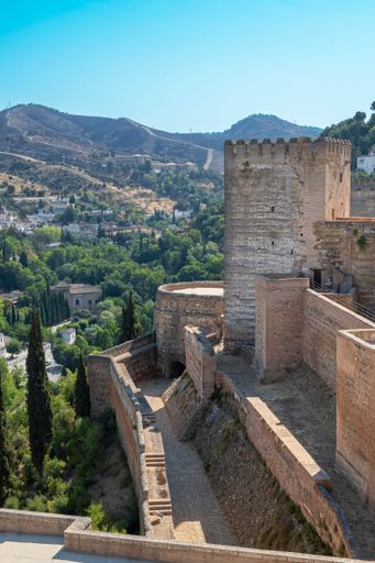 An aerial view of a picturesque mountain town in Spain, featuring winding streets, red-tiled roofs, and a breathtaking landscape in the background