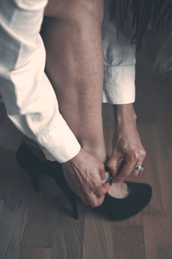 A female wearing black high heels, sitting on a chair
