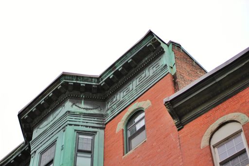 A low angle shot of an brick building with a green facade