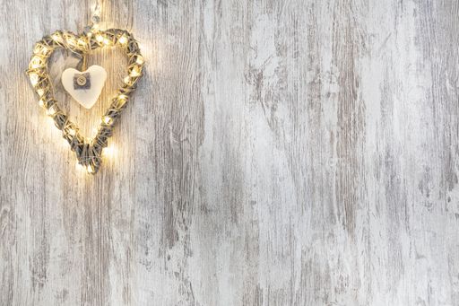 A top view of a wooden heart with lights on a wooden backgroundjj