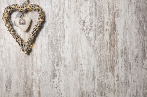 A top view of a wooden heart with lights on a wooden background