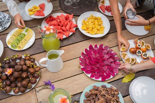 A high angle shot of a wooden table with tropical and exotic sliced fruits