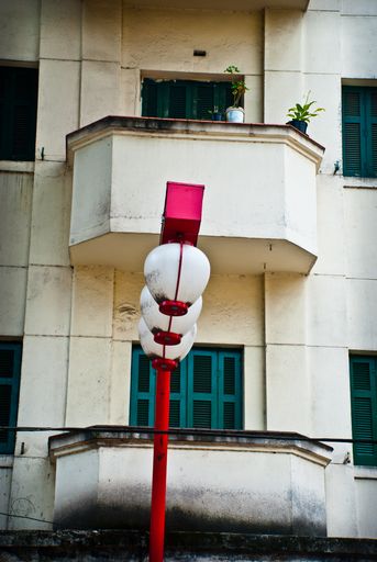 A vertical shot of city lamps in front of a living apartment building, aesthetic wallpaper