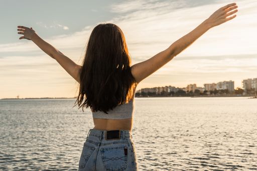 A brunette with open arms on a beach in Benicasim, Spain