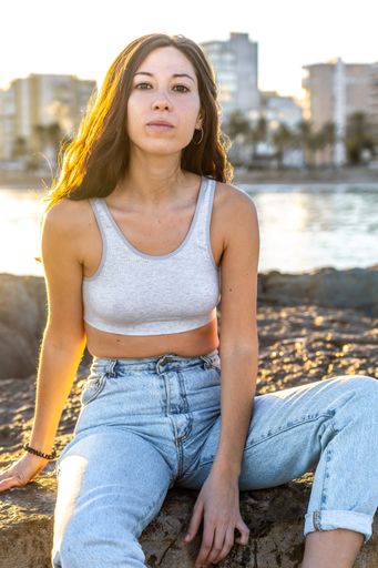 A vertical shallow focus shot of a Caucasian brunette on a beach in Benicasim, Spain