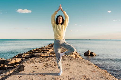 A Caucasian female doing yoga on a beach in Benicasim, Spain