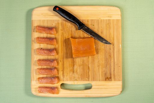 A top view shot of cut fish on a cutting board for sushi