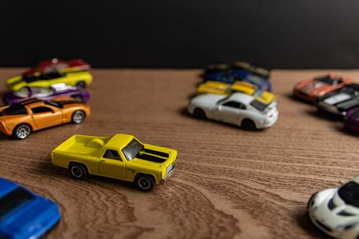 A selective focus shot of yellow toy car on a wooden surface