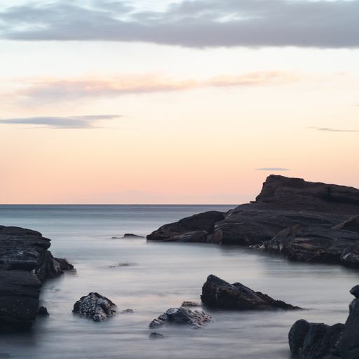 A beautiful scenery of rock formations in the sea under the breathtaking colorful sky