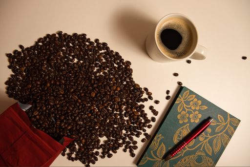 A top view of a cup of coffee and coffee beans on the table
