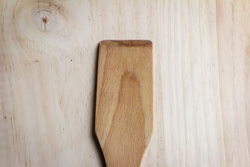 A high angle shot of a wooden spatula on a wooden table