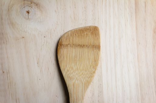 A high angle shot of a wooden spatu on a wooden table