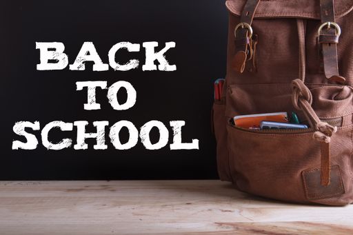 A "Back to school" writing and a backpack with school supplies: notebooks, calculator, pens, pencils