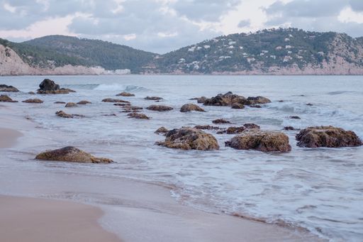 A mesmerizing shot of a rocky seashore under a cloudy sky