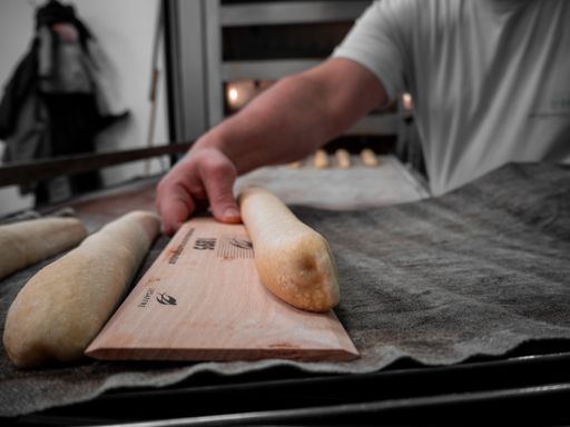 A selective focus shot of the baker making a loaf of bread