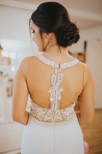 A vertical shot of a back of the bride wearing a bridal dress