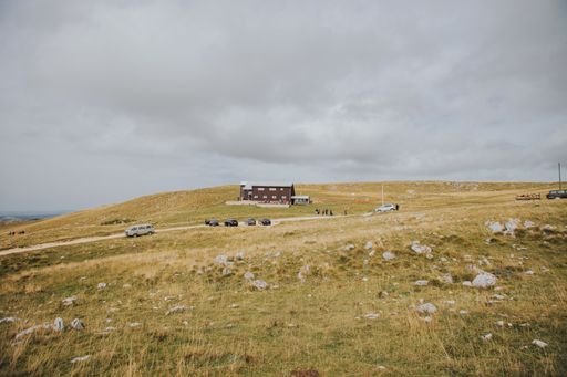 A beautiful shot of a house in the middle of a meadow on the hill in a cloudy weather