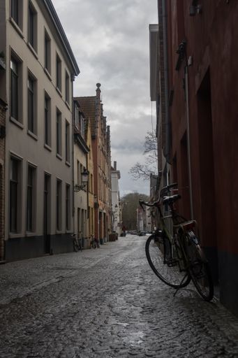 A vertical shot of a bicycle on the streets of Bruges, Belgiu