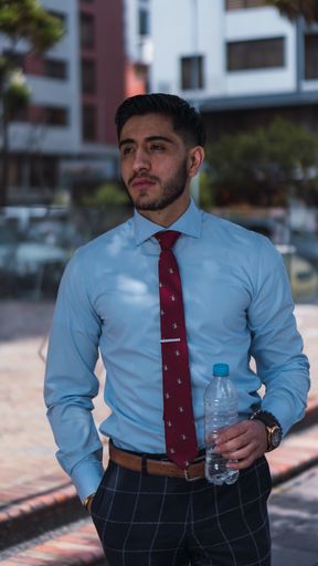 A shallow focus shot of a handsome male with a water bottle posing at camera