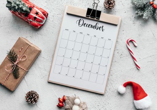 December calendar flat lay. Still life image of calendar and Christmas decorations on table.