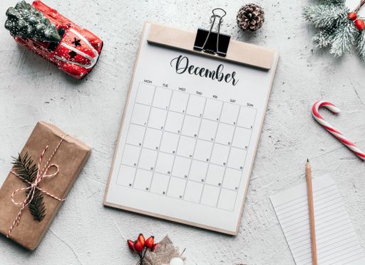 December calendar flat lay. Still life image of calendar and Christmas decorations on table.