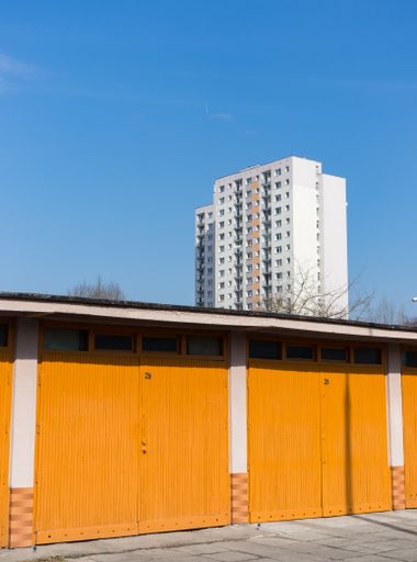 Locked car garages with apartment building in the background