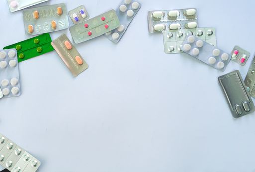 A shot of different piles of medical tablets on a white surface with a copy space