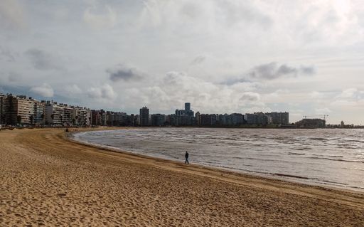 A closeup shot of the sandy beach, the ocean, and the city of Montevideo in Uruguay