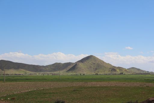 A landscape view with rolling grassy hills under a beautiful cloudscape