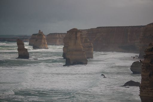 A lot of rock formations near the sea under the cloudy sky during daytime