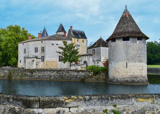An idyllic scene featuring a majestic castle with two impressive towers situated near a tranquil lake