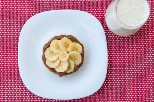 A top view of dessert with bananas and chocolate cream on white plate