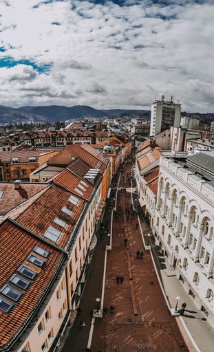 An aerial shot of the city of Banjakuka with bright orange roofs under the clear sky