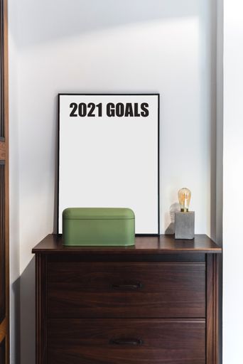 A vertical shot of a wooden table with with a blank 2021 goal board