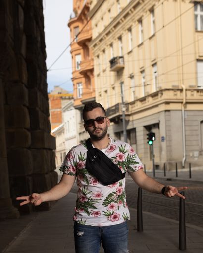 A handsome Caucasian guy in a floral shirt showing peace signs