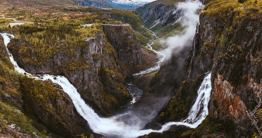 An aerial shot of the beautiful waterfalls over the mountains captured in Norway