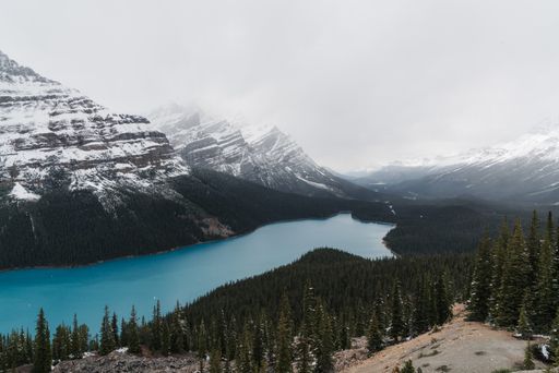 A high angle shot of a clear frozen lake surrounded by a mountainous scenery