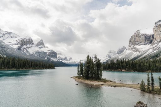 A high angle shot of a clear frozen lake surrounded by a mountainous scenery
