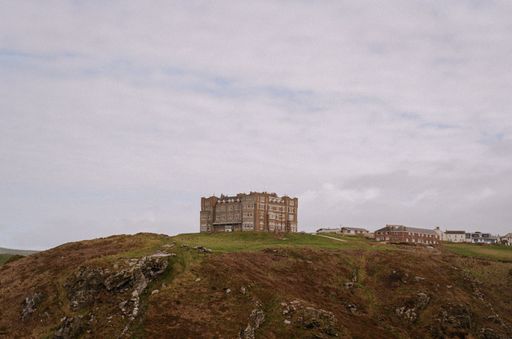 A scenic view of old majestic Tintagel castle on green hill on cloudy day in Tintagel, Cornwall, UK