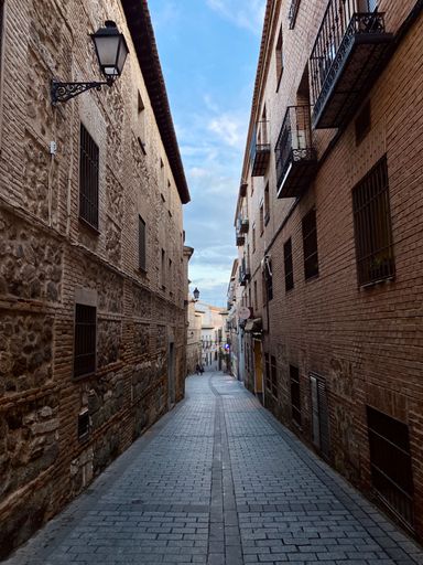 A picturesque view of a quaint, narrow cobblestone street.