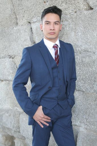A vertical shot of a male model in a suit. Professional looking man outside