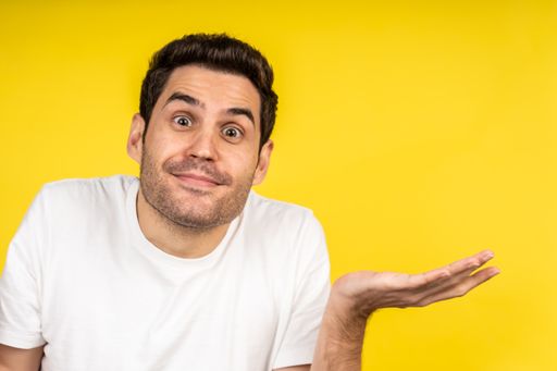 A handsome Caucasian man wearing a shirt and posing on a yellow background - copy space