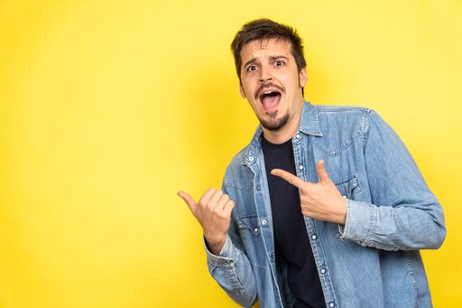 A handsome Caucasian man posing on a yellow background