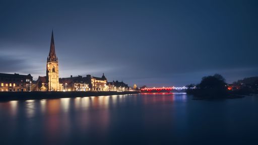 A well-known view looking across the River Tay to St Matthew's Church of Scotland and the red and blue lights on Smeaton's Bridge.